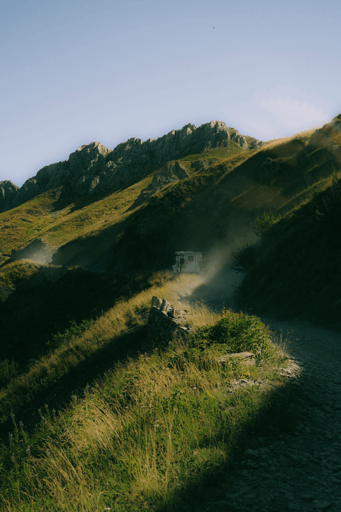 Suzuki Jimny driving the Salt Road Italy 4x4 with mountain views and bikers on the trail